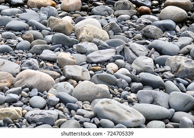 Gray and dark round rocks on seashore