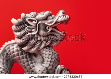 Gray dragon statue on a red background. The symbol of 2024. Happy Chinese New Year.