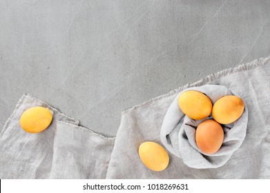Gray Easter background with yellow bright eggs on the textured gray table. Copy space