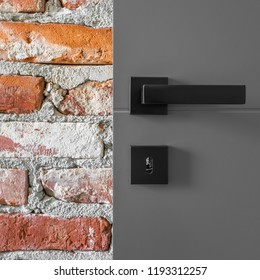 Gray Entry Door With Black Handle And Industrial Brick Wall, Close Up