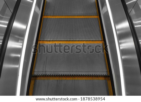 Gray escalator steps with orange lines close-up. Stopped escalator.