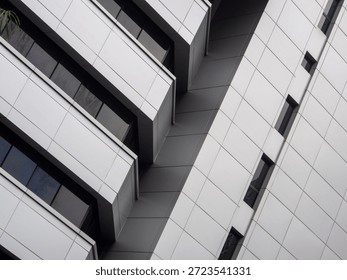 Gray exterior of a building with rectangular panels and glass windows.