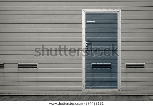 Gray garage gate with ventilation grilles.\
Large automatic up and over garage door with inclusion of smaller\
personal door. Multicolor background\
set