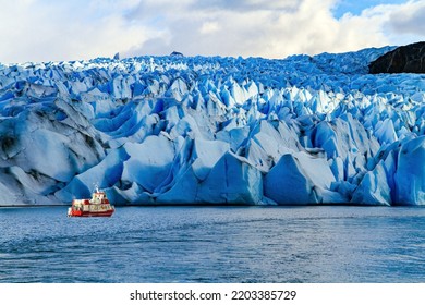 Gray Glacier is part of the South Patagonian Ice Field. The Gray Glacier is the third largest in the world. Boat with tourists floats among icebergs.  - Powered by Shutterstock