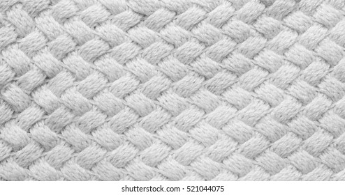Gray grey knitted carpet closeup. Textile texture off white background. Detailed warm yarn background. Knitted background, cashmere yarn.