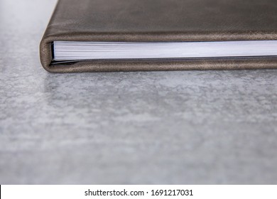 Gray Grey Leather Bound Book Photo Album With Thick Pages Laying On A A Light Colored Surface With A Marbled White And Gray Background With Lots Of Copy Space For Text With Copy Space