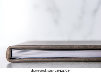 Gray Grey Leather Bound Book Photo Album With Thick Pages Laying On A A Light Colored Surface With A Marbled White And Gray Background With Lots Of Copy Space For Text With Copy Space