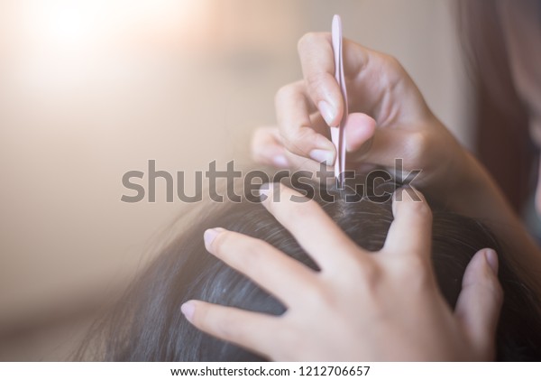 グレイの髪とピンセット 女性の手とピンセットがグレイの髪の根を引っ張る 手を近くに持ち 白い髪を頭から取り除く の写真素材 今すぐ編集