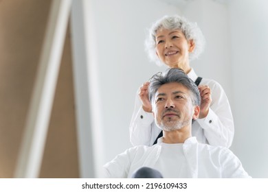 Gray Hairdresser Setting Hair For Senior Man.