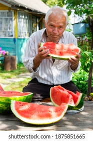 Gray Haired Old Man Eating A Huge Ripe Watermelon Near The Village House