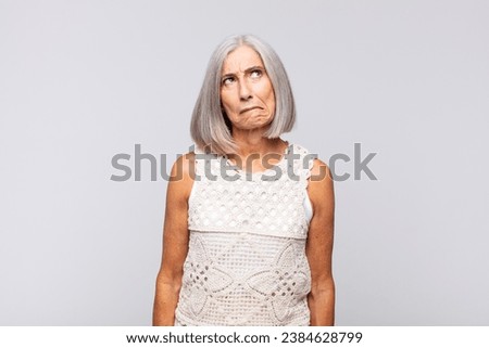 gray haired woman looking goofy and funny with a silly cross-eyed expression, joking and fooling around