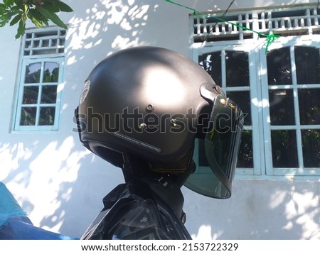 gray helmet above the motorcycle mirror