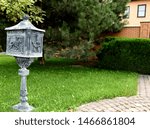 Gray lantern, mailbox installed on a green lawn