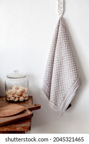 Gray, Linen Tea Towel Hanging On A Kitchen Wall In A Kitchen Interior With Wooden Table, Biscuits And Board