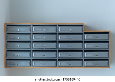 gray mailboxes on the blue wall of entrance of apartment house