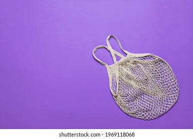 A Gray Mesh Bag On A Purple Background. Vintage Grocery Bag.