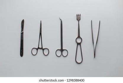 Gray Metal Medical Instruments For Neurosurgery On A White Table In The Operating Room. View From Above.