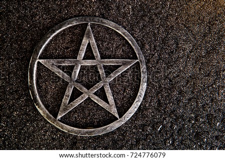 Gray metal pentagram on slate background with water drops - with copy space