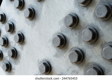 Gray metal surface with hexagonal bolt heads.