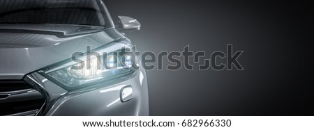 Gray modern car closeup on black background.