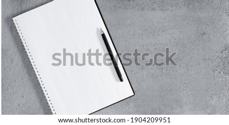 Gray office desk. Open notebook and pen on gray desk background. Flat lay, top view, copy space, banner