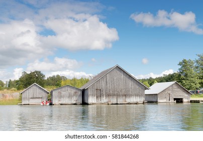 Gray old boathouses, blue sky and white clouds in the archipelago in Aland, Finland