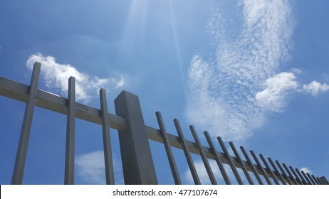 Gray Painted Metal Fence With Blue Sky Background