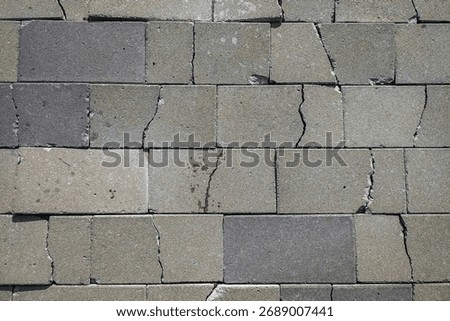 Gray paving block texture with cracks and natural damage, rough surface detail perfect for background, architecture, construction, and creative design use.
