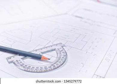 Gray pencil with a protractor in the drawings. Design and working drawings with pencils, rule and compasses. Flat lay, place for text.