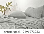 gray pillow and natural linen bed sheet