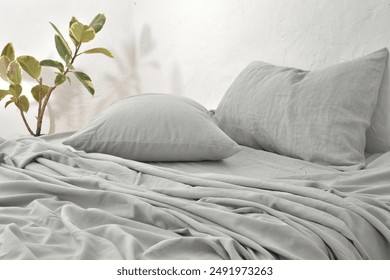 gray pillow and natural linen bed sheet