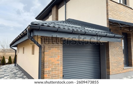 Gray plastic gutter system on a garage