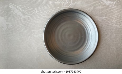 A Gray Plate In A Sushi Restaurant Placed On The Paper, Fish Shape, Top View.