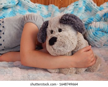 Gray Plush Dog On A Crib In The Arms Of A Girl Hiding Behind A Toy