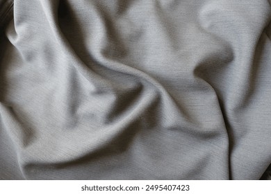 gray polyester fabric with herringbone pattern in soft folds