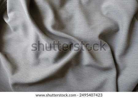 gray polyester fabric with herringbone pattern in soft folds