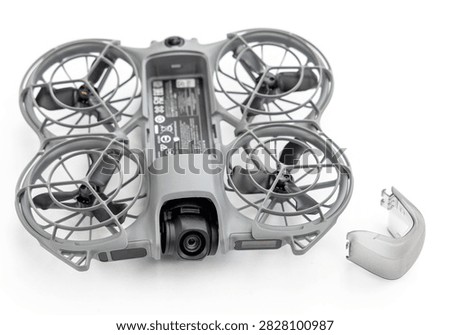 A gray quadcopter drone with propeller guards on white background