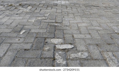 Gray rectangular interlocking pavers on the ground, urban sidewalk surface texture.