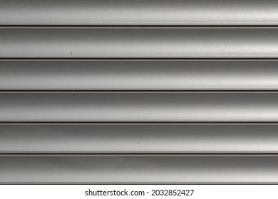 Gray Roller Shutters. Folding Door Made Of Rolled Steel. Texture Of Metal Roller Door Curtain.