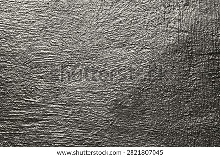 Gray shiny wall, background, texture. Uneven, grooved and embossed silvery backdrop. Grey surface with silver porous color. Abstract textured surface. The wall, painted with metallic, platinum paint