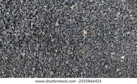 Gray small rocks ground texture. black small road stone background. gravel pebbles stone seamless texture. dark background of crushed granite gravel, close up. clumping clay