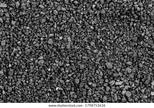 Gray small rocks\
ground texture. black small road stone background. gravel pebbles\
stone seamless texture. dark background of crushed granite gravel,\
close up. clumping clay