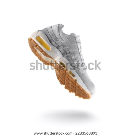 Gray sneaker with light yellow accents on a white isolated background, sport concept, men's fashion, sport shoe, air, sneakers, lifestyle, concept, product photo, levitation concept, street 
