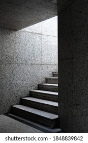 
gray stairs going down stone wall