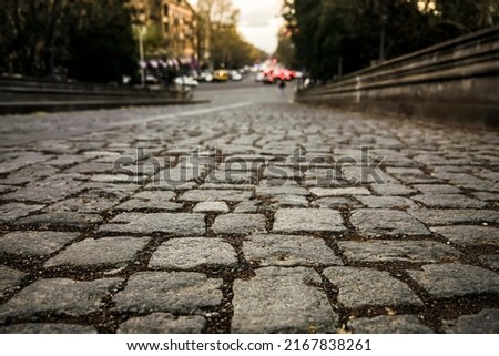 gray stone road surface, cobbled road, cobble background. texture old stone pavement in the old totwn. view in perspective.
