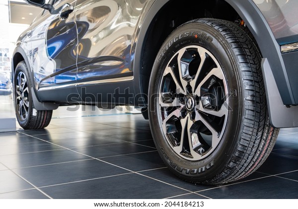 Gray SUV Renault Arkana at the showroom. Bridgestone\
tire is mounted on cast aluminum rim. Close-up of rear left wheel.\
Renault car dealership in Mega Adygea. Krasnodar, Russia - August\
26, 2021
