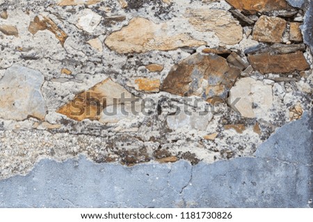 Gray textured concrete wall with blue peeling paints. Dirty painted stone background