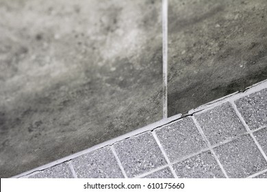 Gray Tile Grout In A Home Shower That Has Broken Apart And Needs Repair. Cracked And Split Grout In A House Shower Corner Between The Wall And Floor That Needs Fixing.
