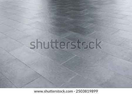 The gray tiled floor is bare and empty. The flooring around the house.