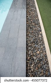Gray tiles and stones line design for edge of swimming pool. Structure Side of Swimming pool and rocks and grass at side design for landscape background. 